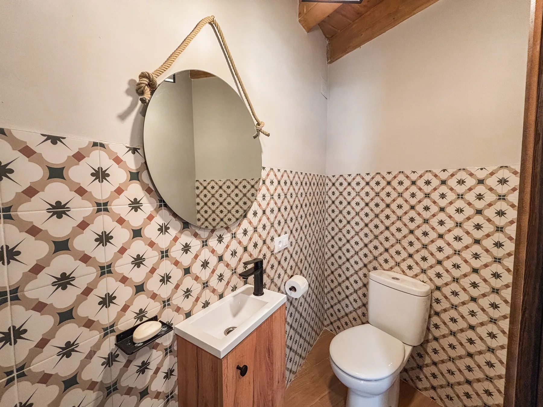 Aseo con azulejos de patrón y espejo redondo