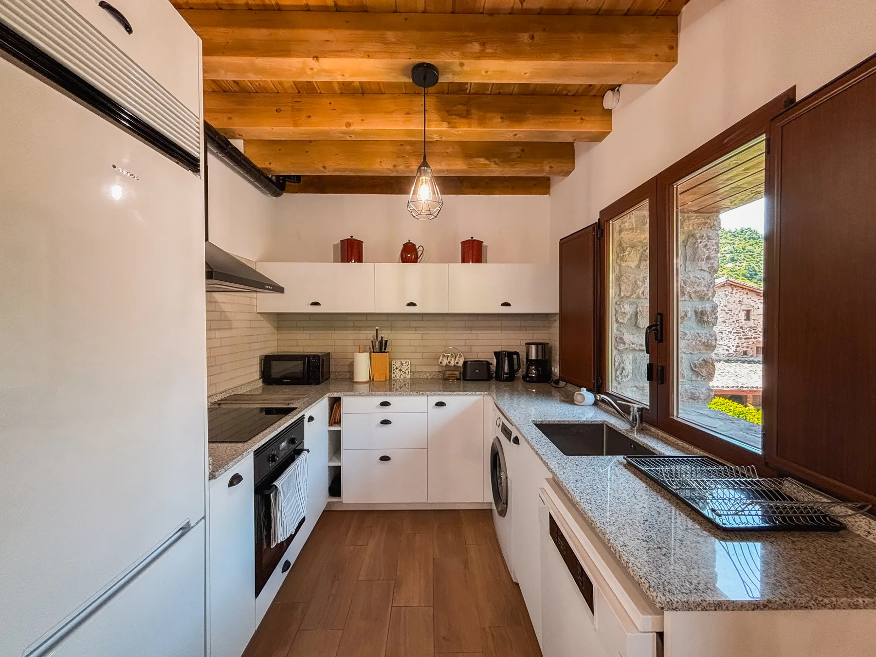 Cocina equipada con encimera de granito y vigas