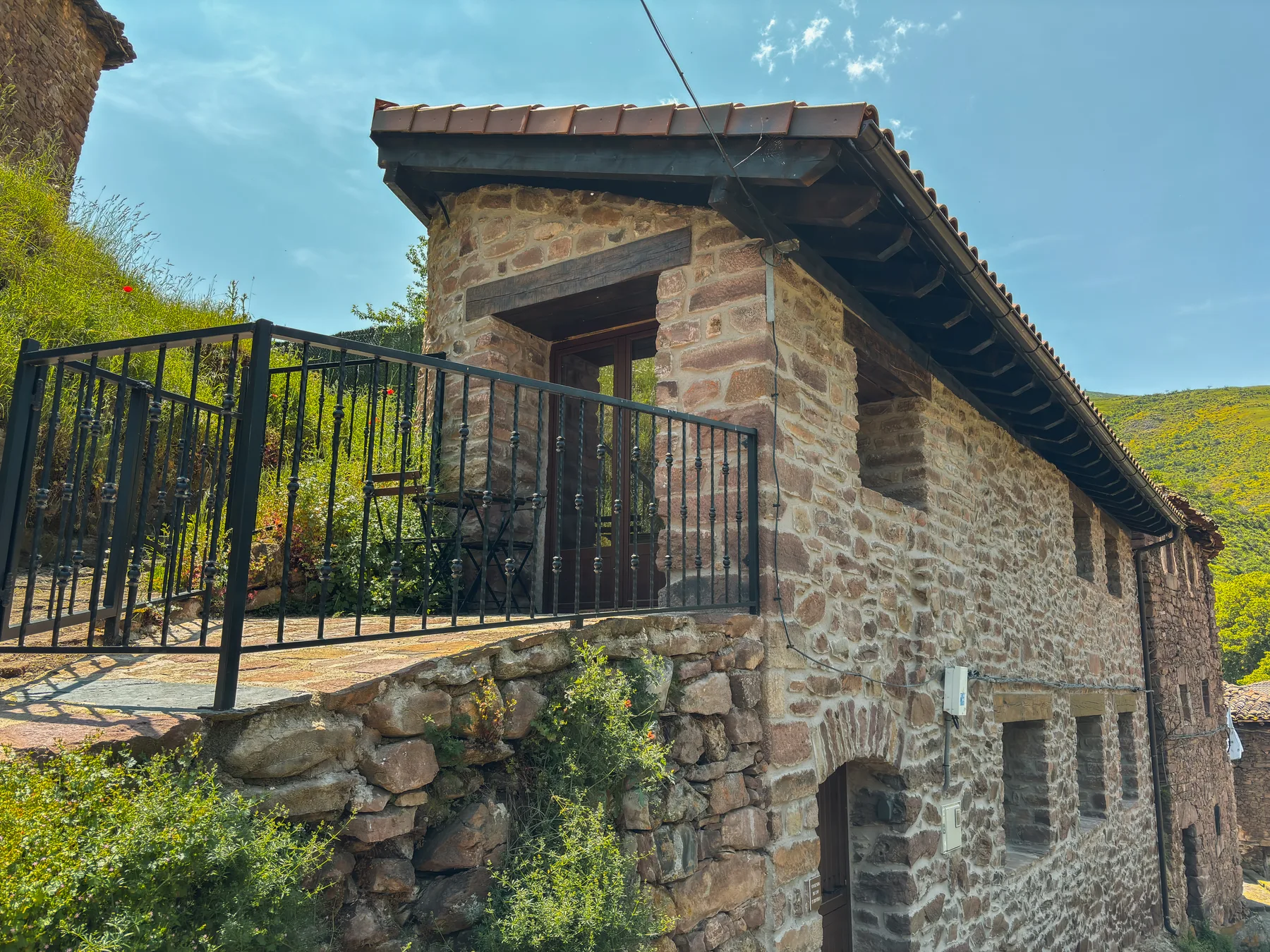 Fachada frontal con balcón y montaña al fondo